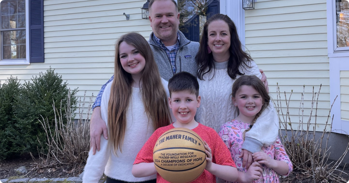 Family of five posing together while a young boy holds an FPWR Champions of Hope basketball.