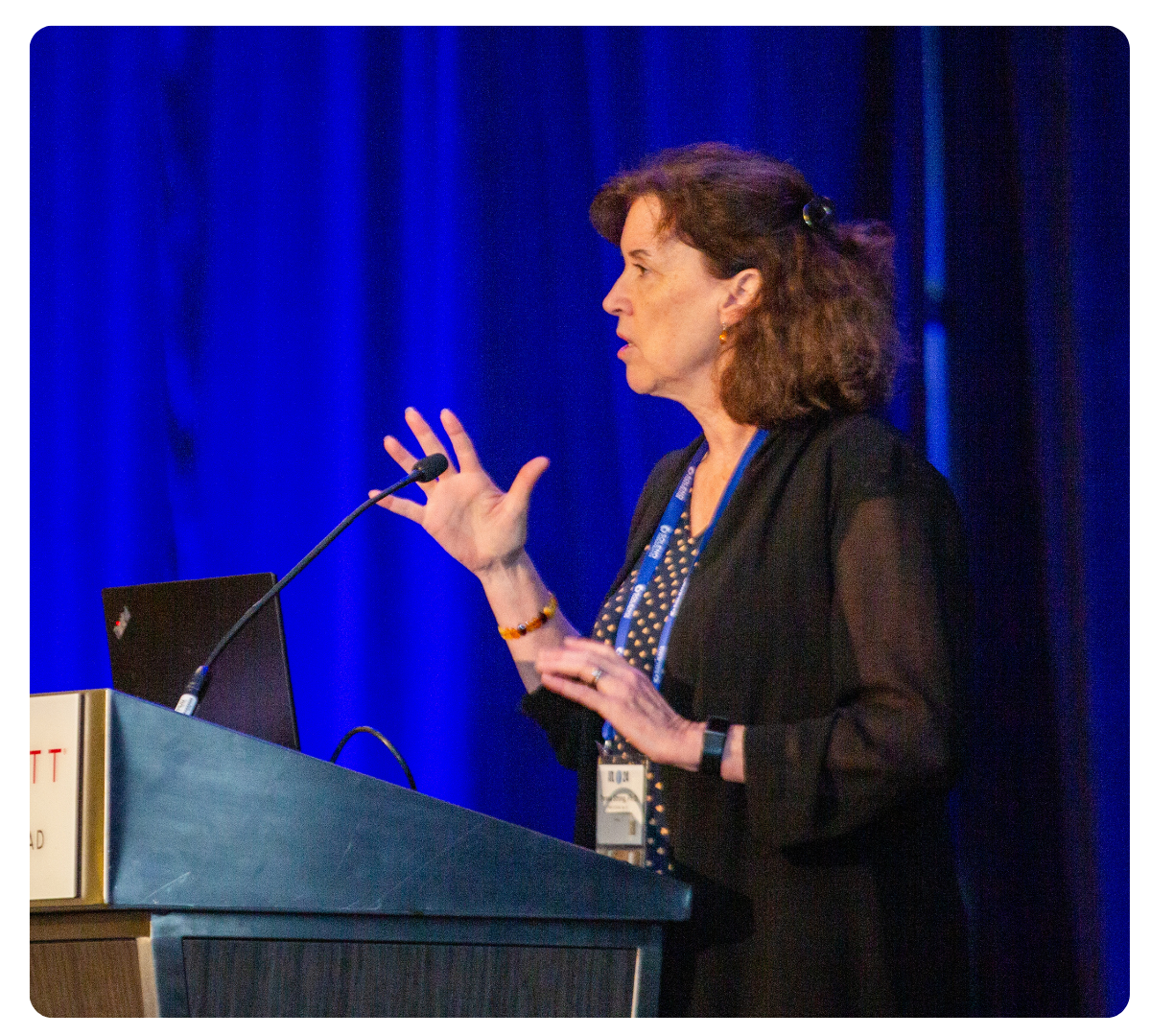 Woman speaking at a podium during an FPWR conference presentation.